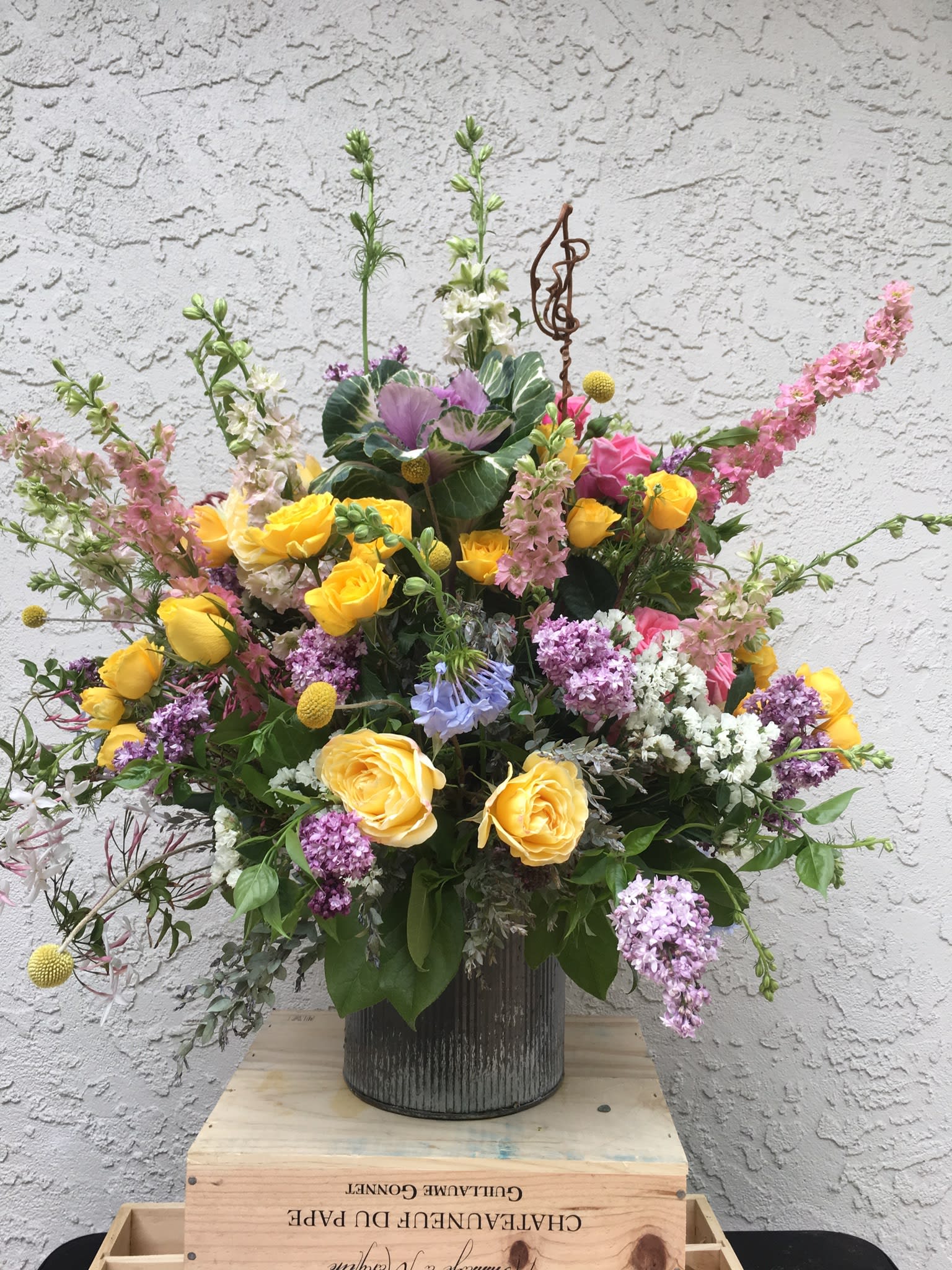 Large mixed bouquet of yellow and pink roses in a metal vase