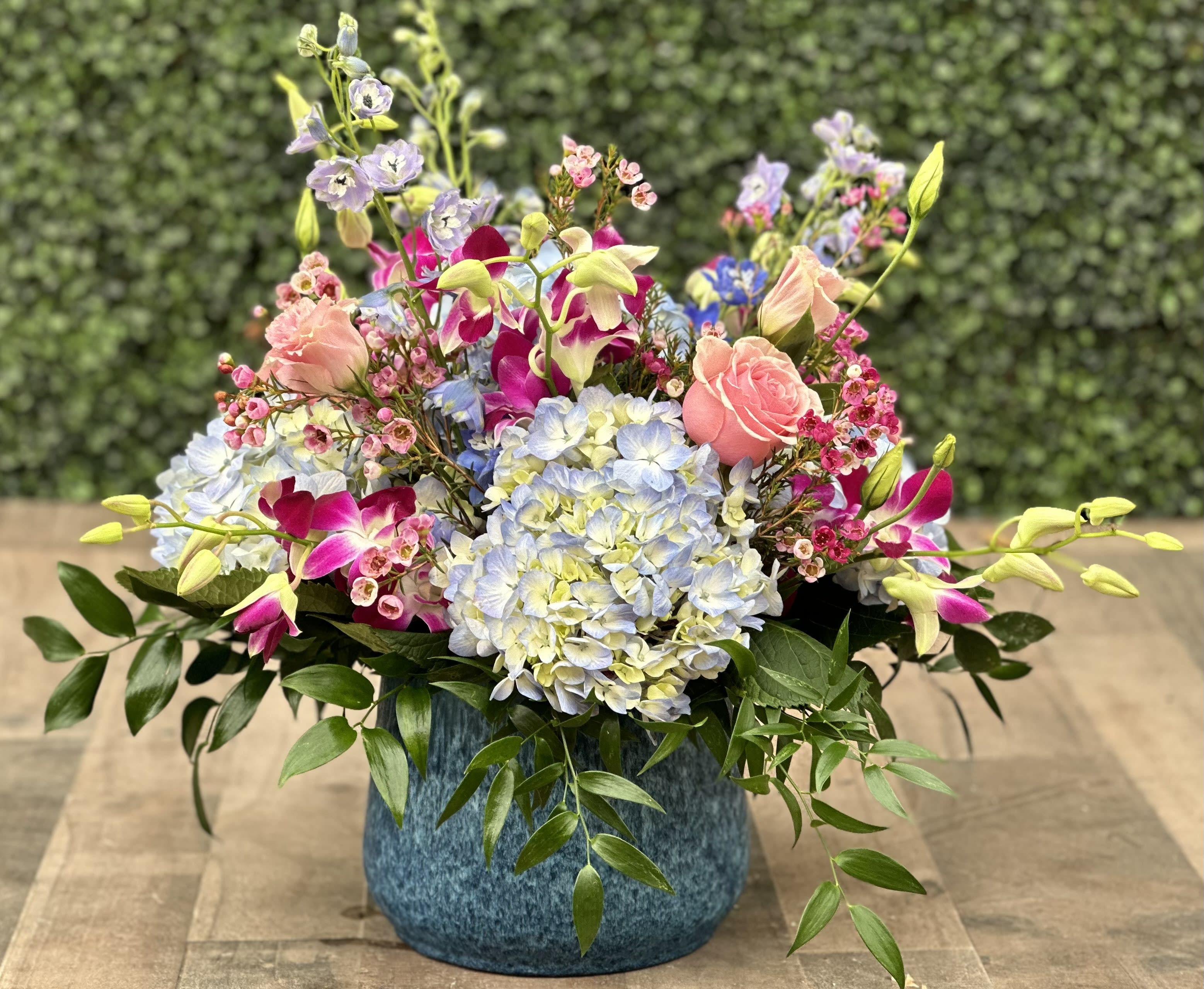 Colorful mixed flower arrangement in a blue vase