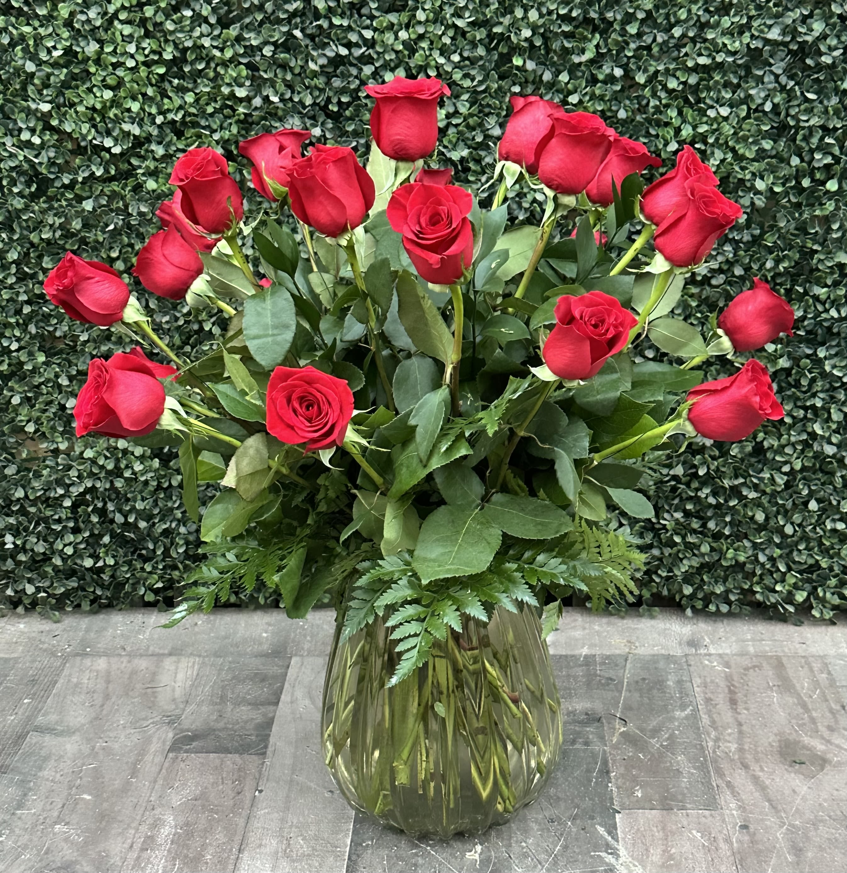 Red roses arranged in a clear glass vase
