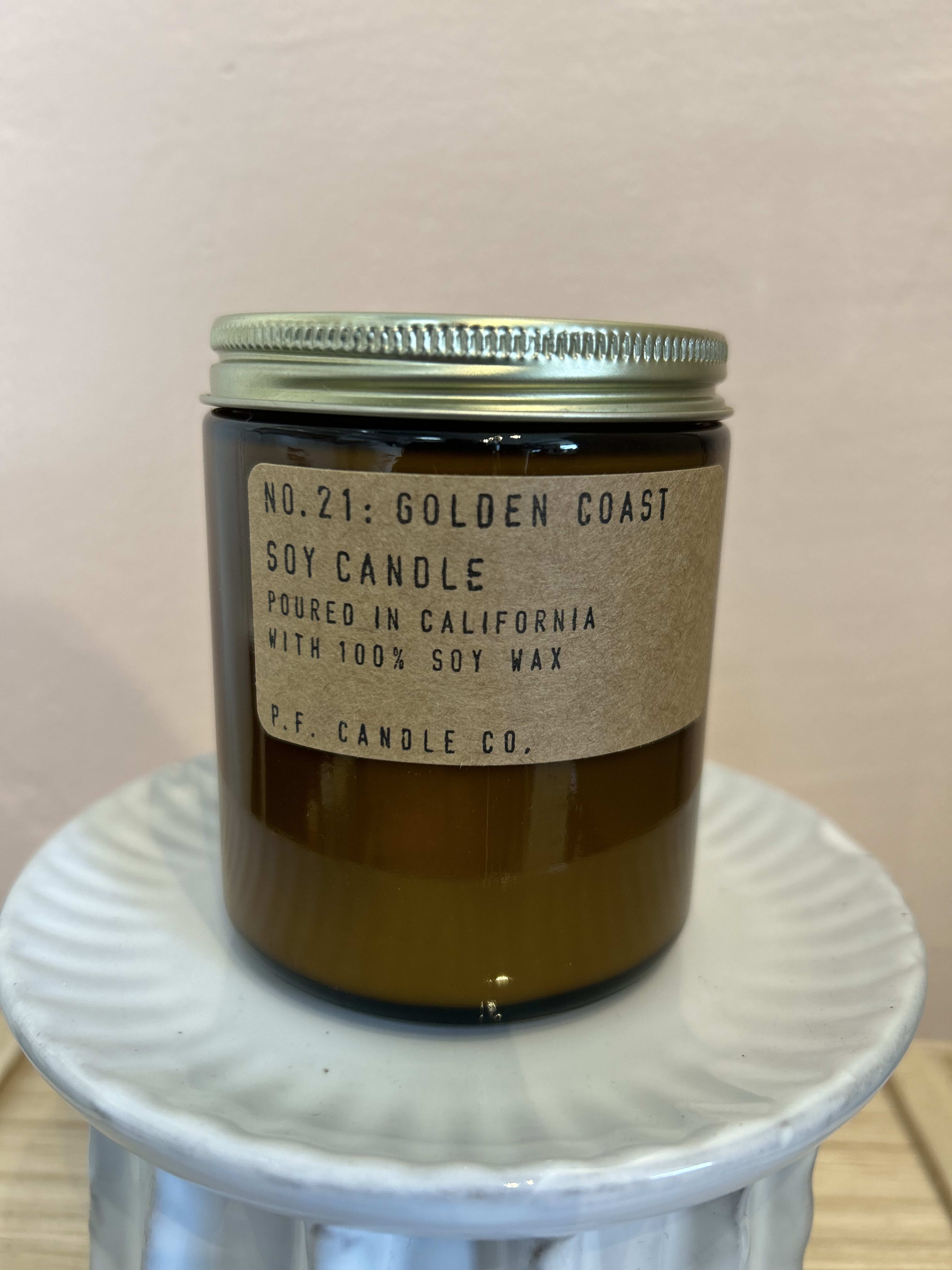 Amber jar candle with a metal lid and paper label