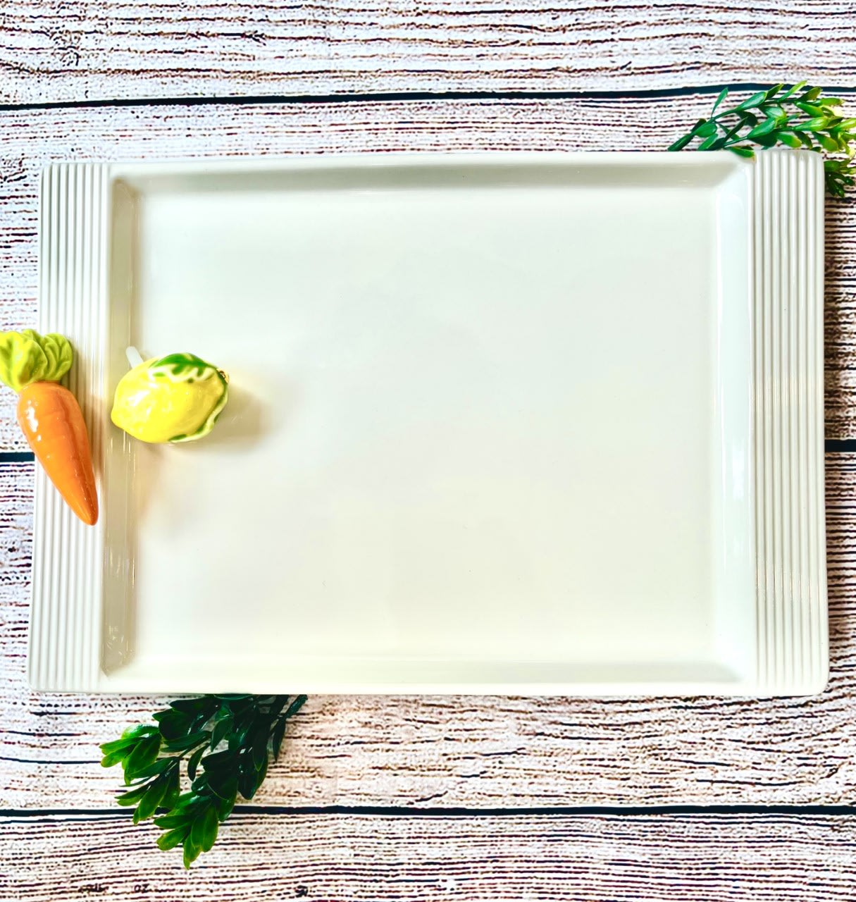 White rectangular serving tray with small vegetable decorations