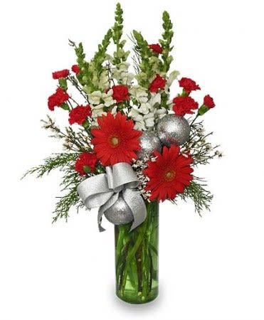 Tall red and white flower arrangement with silver ornaments in a green glass vase