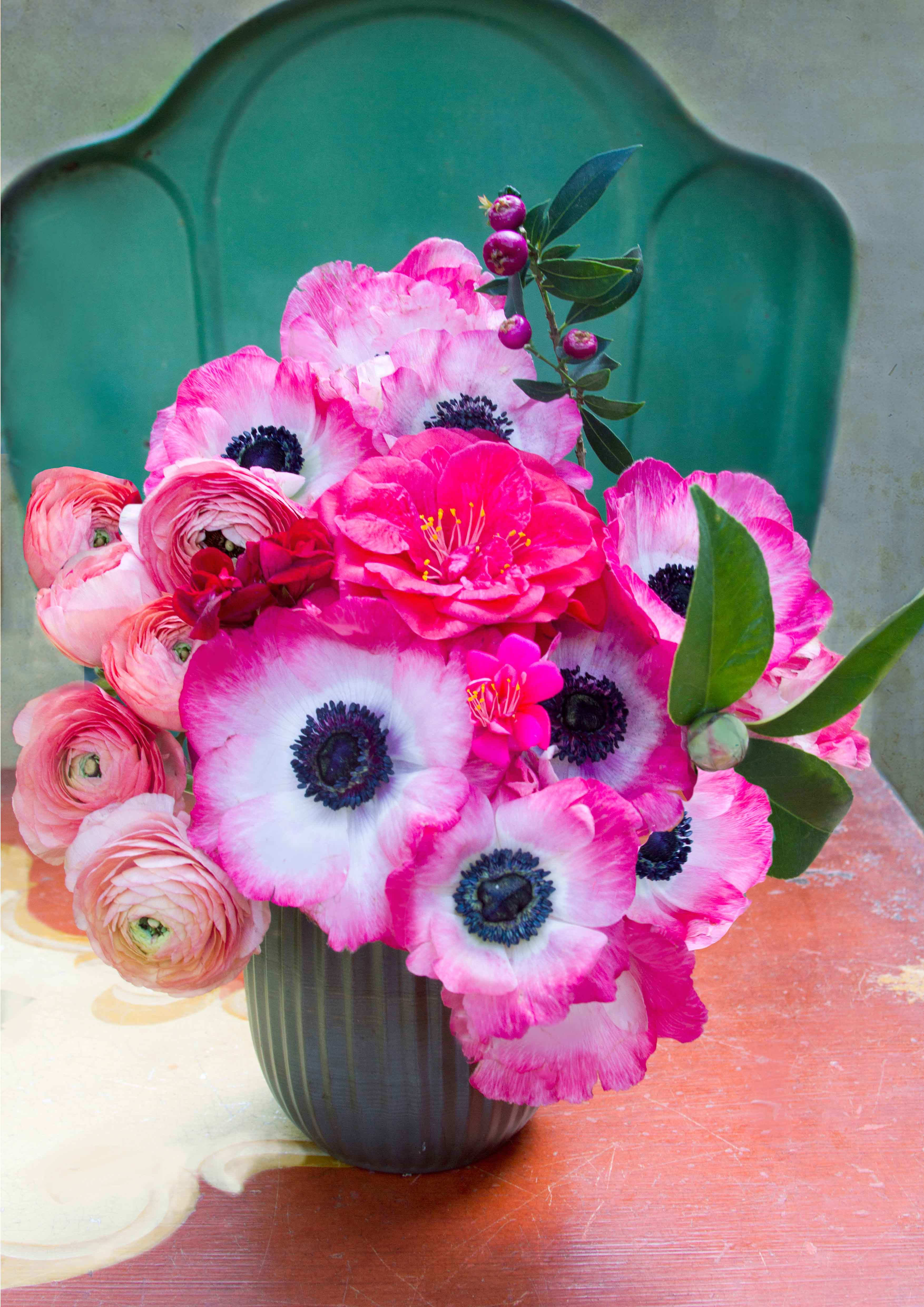 Pink and white anemones with ranunculus in a dark vase