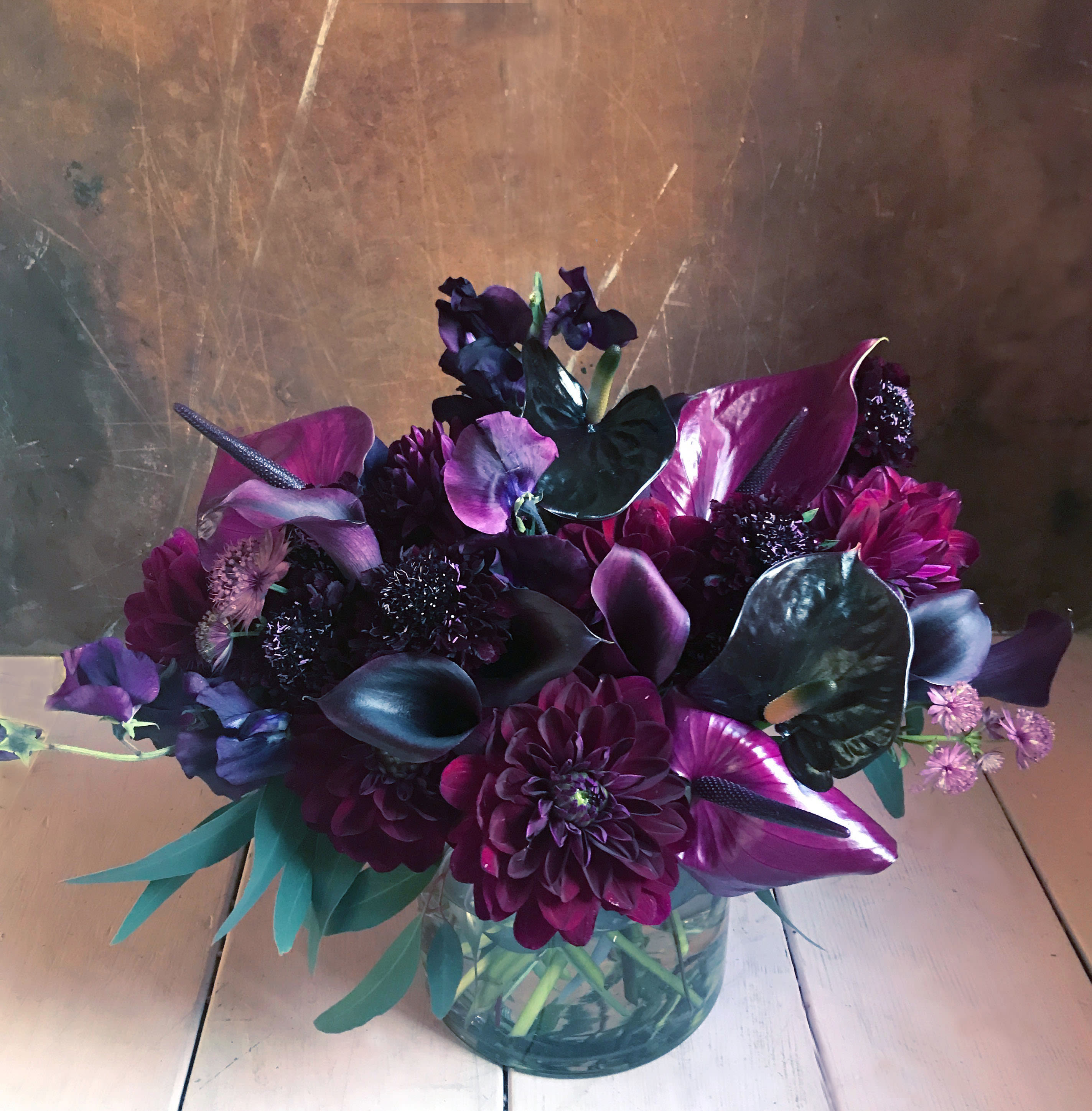 Purple floral arrangement in a clear glass vase