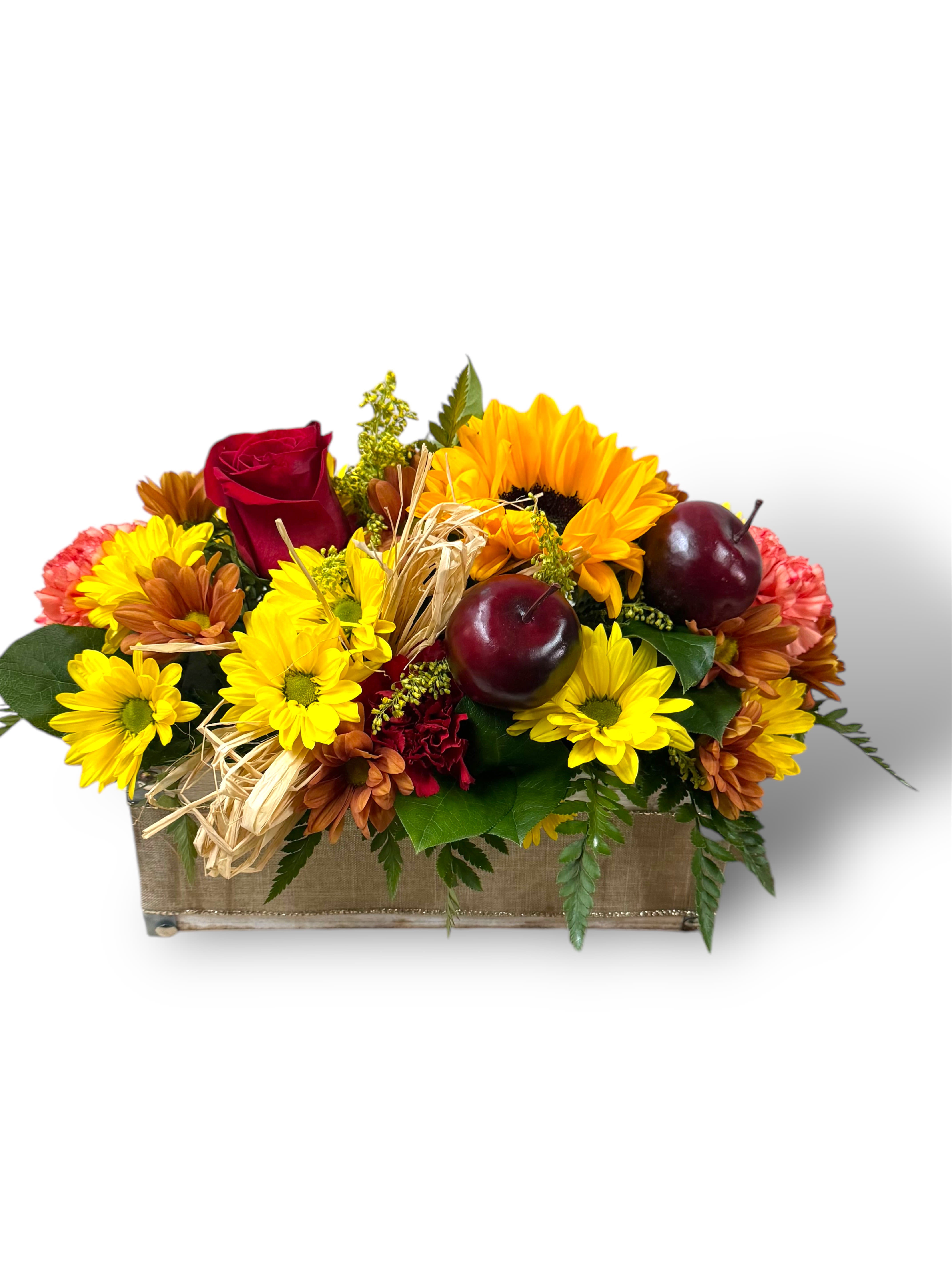 Mixed yellow and red flowers arranged in a rectangular box with decorative apples