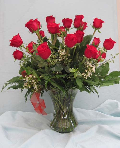 Red roses arranged in a clear glass vase