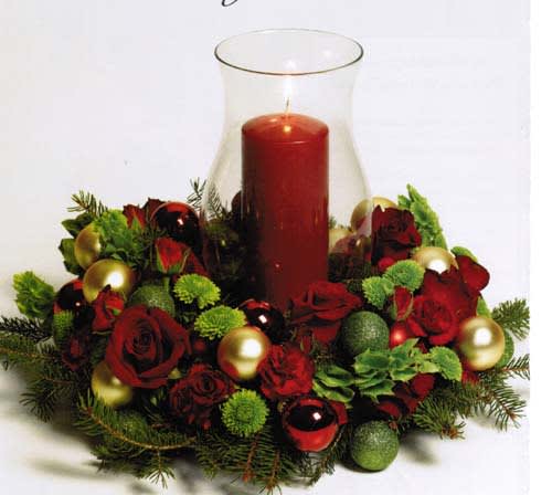 Red rose centerpiece with a tall red candle in a glass hurricane vase