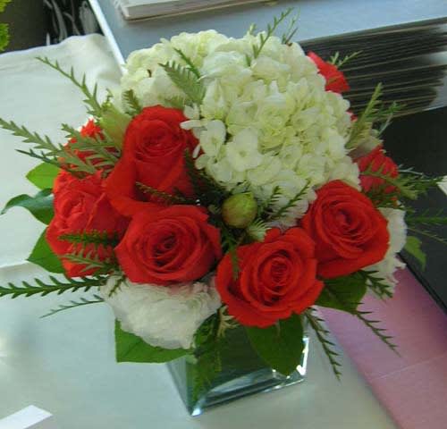 Red roses and white hydrangeas in a clear glass vase