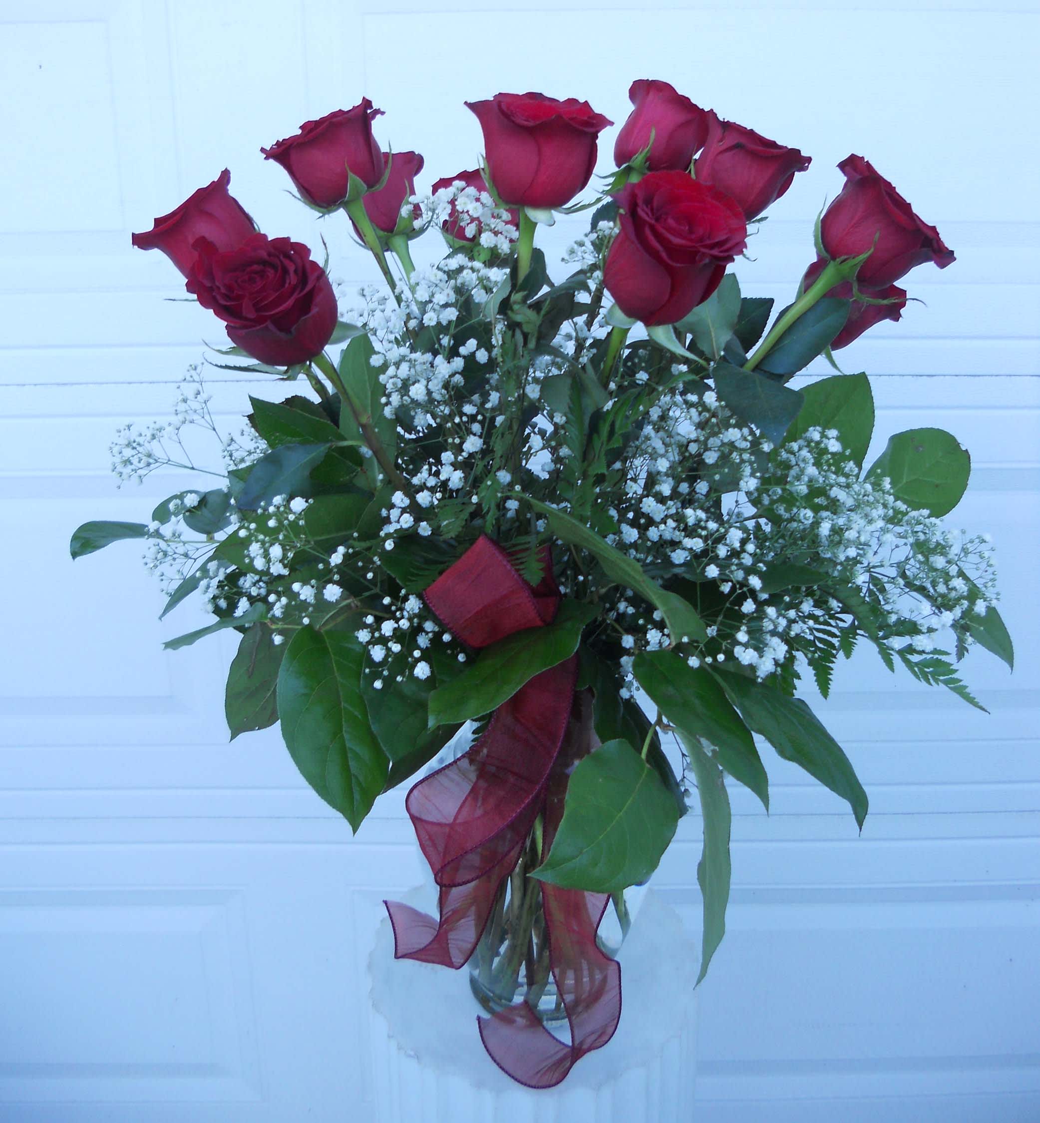 Bouquet of red roses with white baby's breath in a glass vase