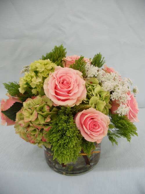 Pink roses and green hydrangeas in a glass vase
