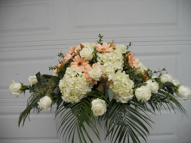 White roses and pale peach daisies in a low floral arrangement