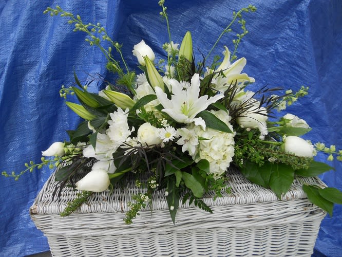 White floral arrangement in a white wicker basket
