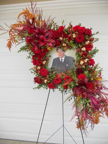 Standing floral wreath with red roses around a portrait photo