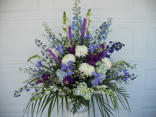 Large blue, purple, and white floral arrangement in a vase