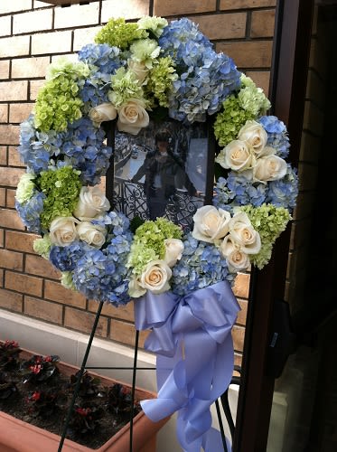 Blue and green floral wreath with cream roses on a stand