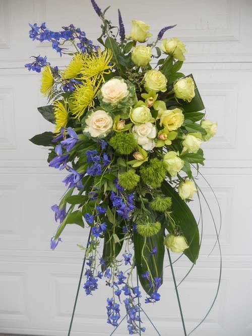 Tall floral spray with yellow, white, and blue flowers on a stand