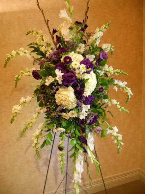 Tall floral spray with purple and white flowers on a stand
