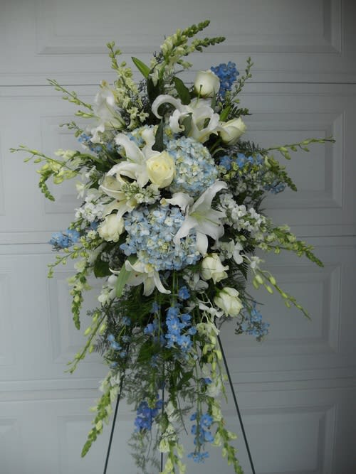 Tall white and blue floral standing spray on an easel