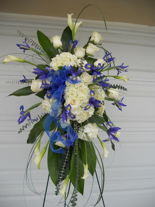 Tall floral spray with white roses, hydrangeas, and blue accents
