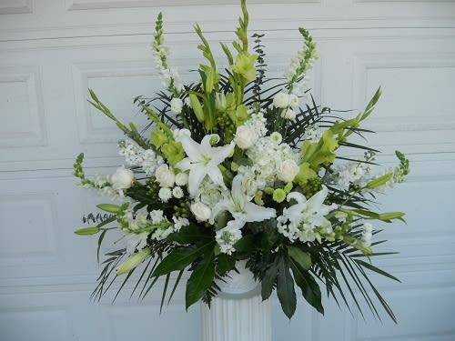 White and green floral arrangement in a pedestal vase