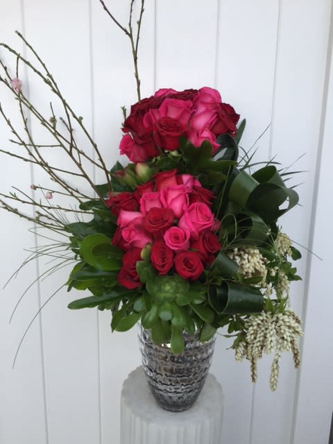 Pink and red rose arrangement in a patterned vase