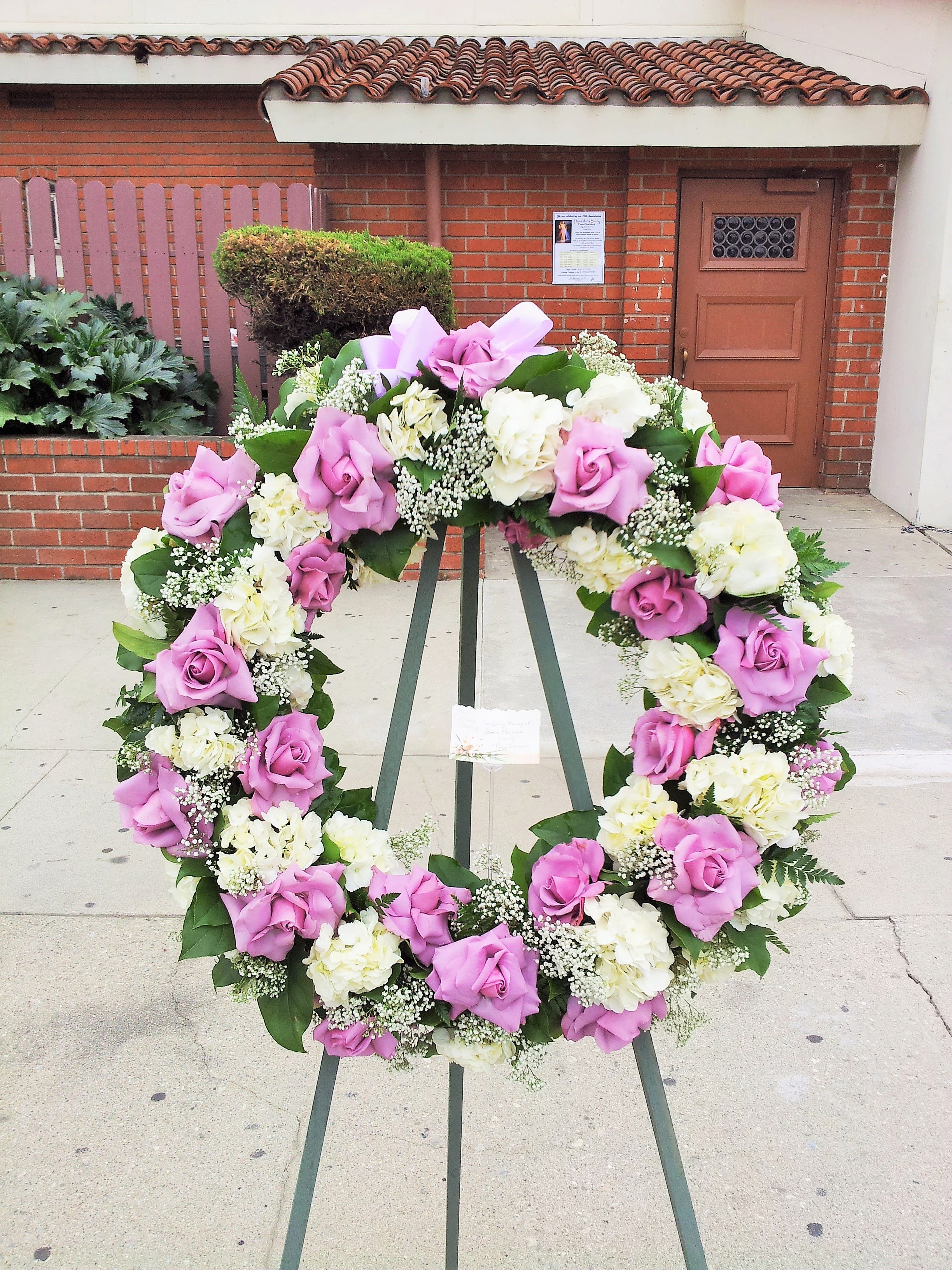 Pink and white floral wreath on a stand
