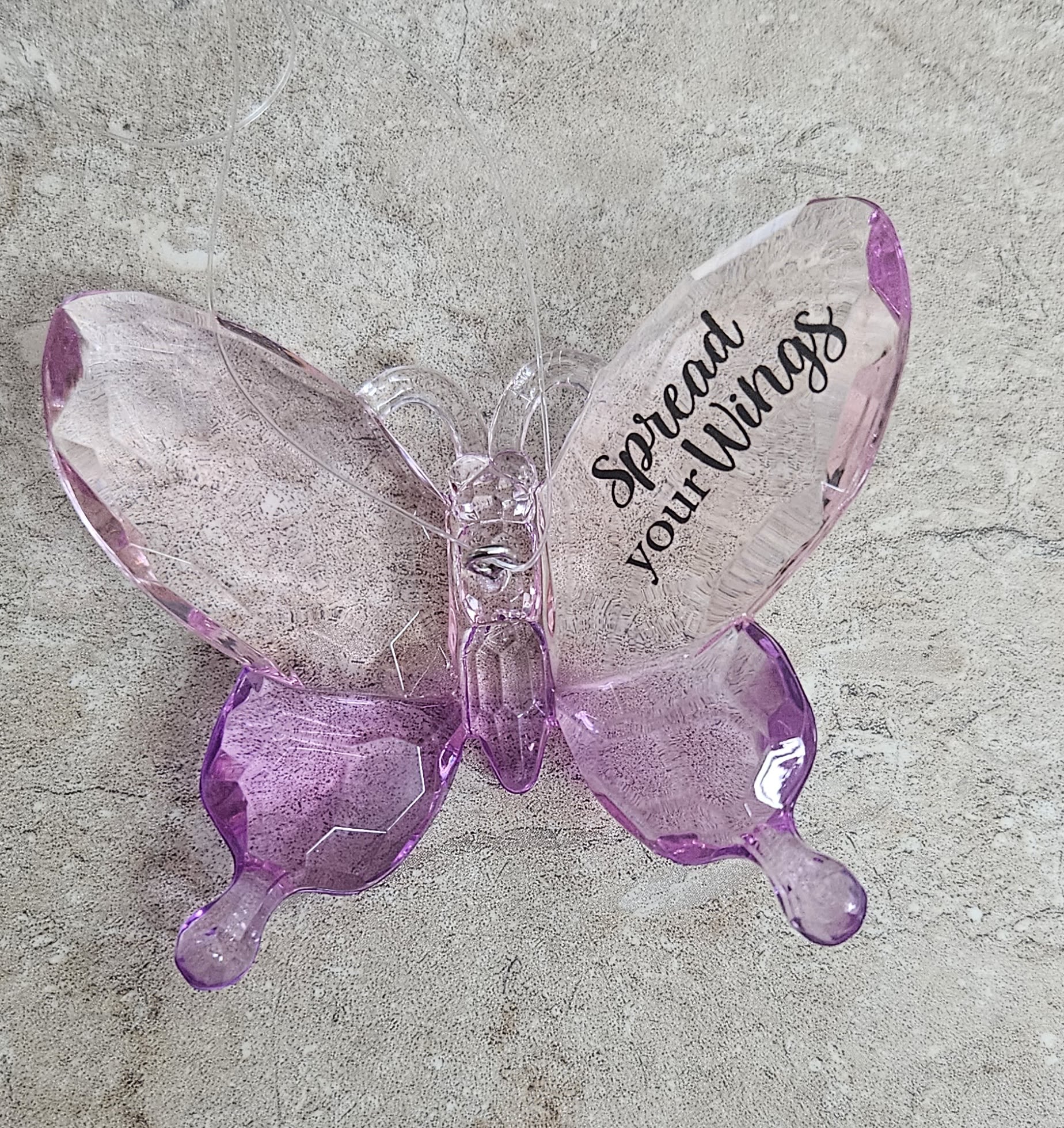 Pink translucent butterfly ornament with the words "Spread your Wings"