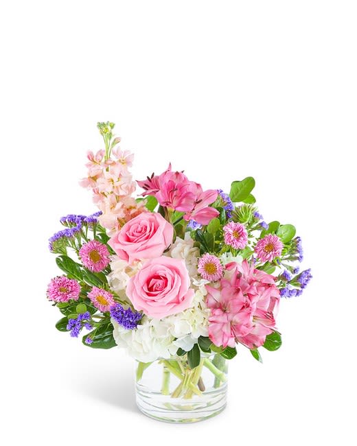 Pink roses and mixed flowers in a clear glass vase