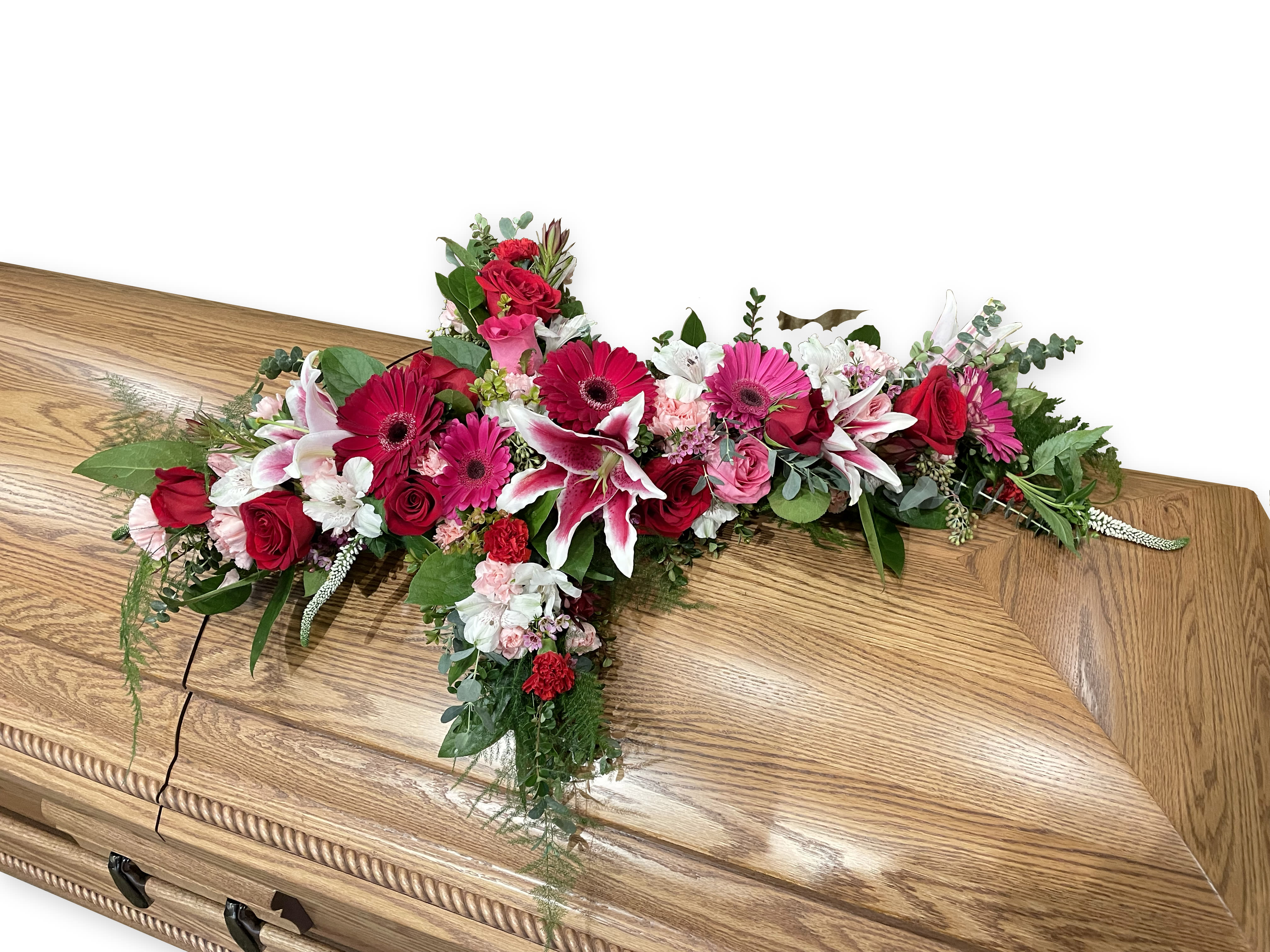 Floral casket spray with red, pink, and white blooms