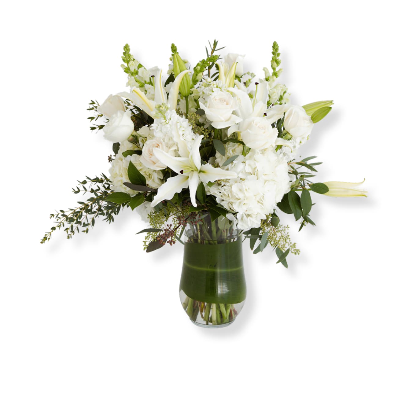 White floral arrangement in a glass vase with lilies and roses