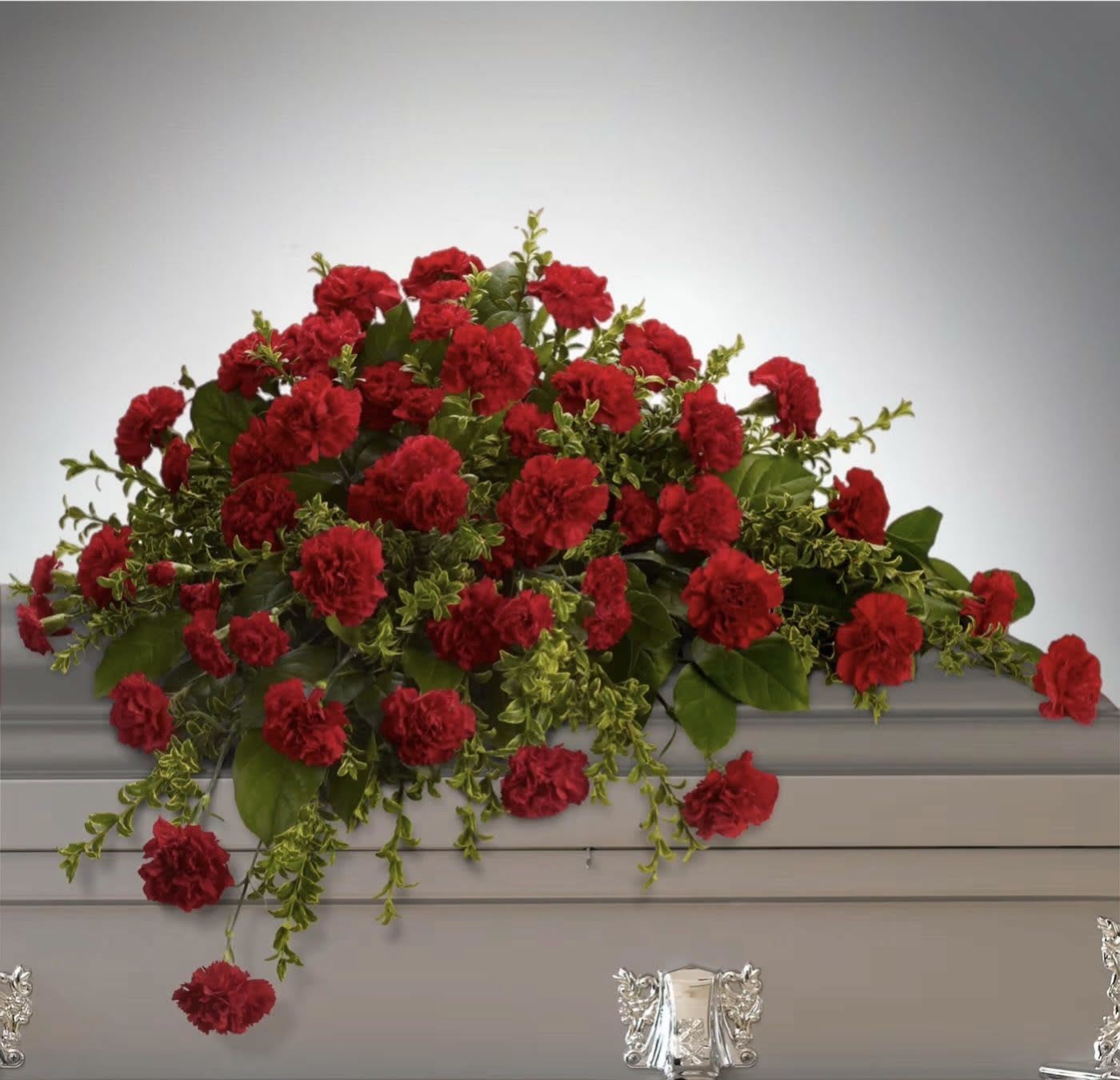 Adoration Casket Spray - This classic half-couch spray of brilliant red carnations makes a striking and dignified statement.  Radiant red carnations and miniature carnations accented by fresh greenery arrive in a lovely spray.  Approximately 36" W x 27" H  Orientation: N/A      As Shown : T242-2A  