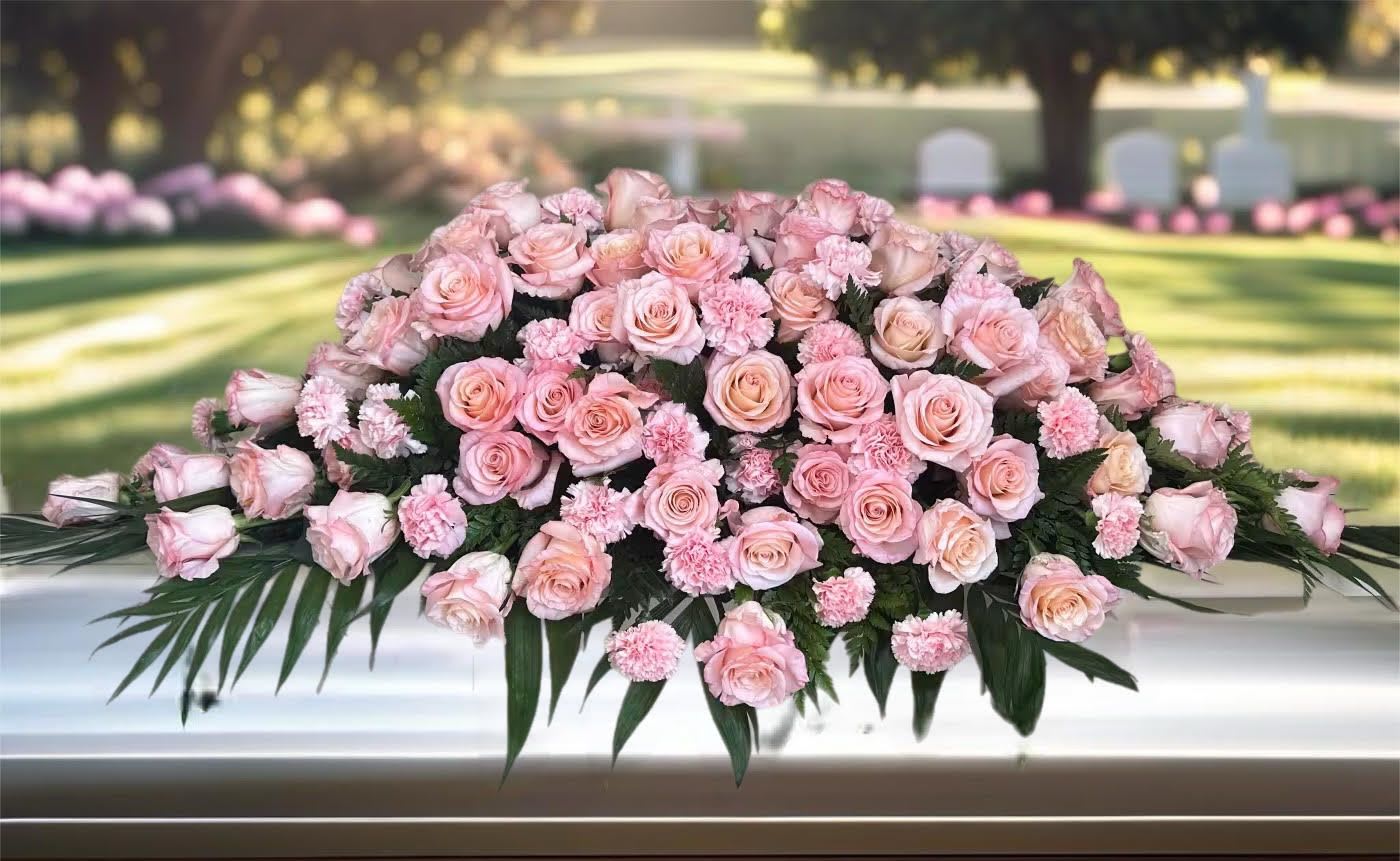 Pink rose and carnation casket spray with dark greenery