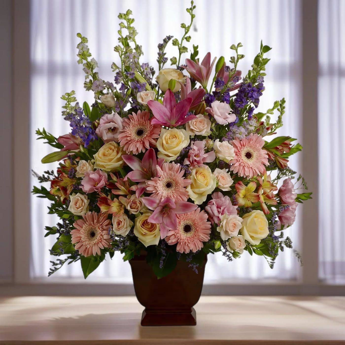 Mixed pink and cream flowers in a dark vase
