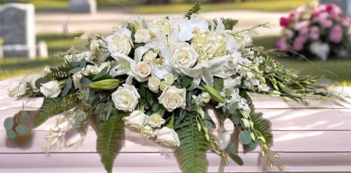 White floral casket spray with roses and lilies