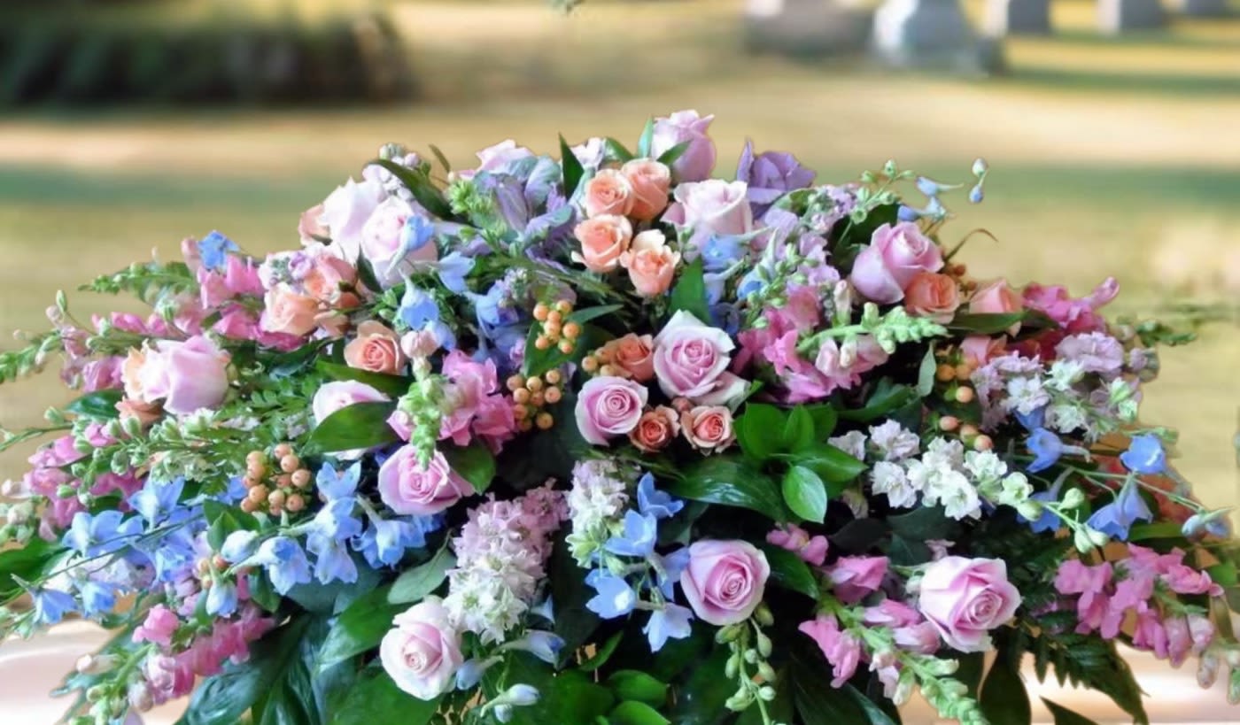 Large pastel floral arrangement with pink roses and blue flowers