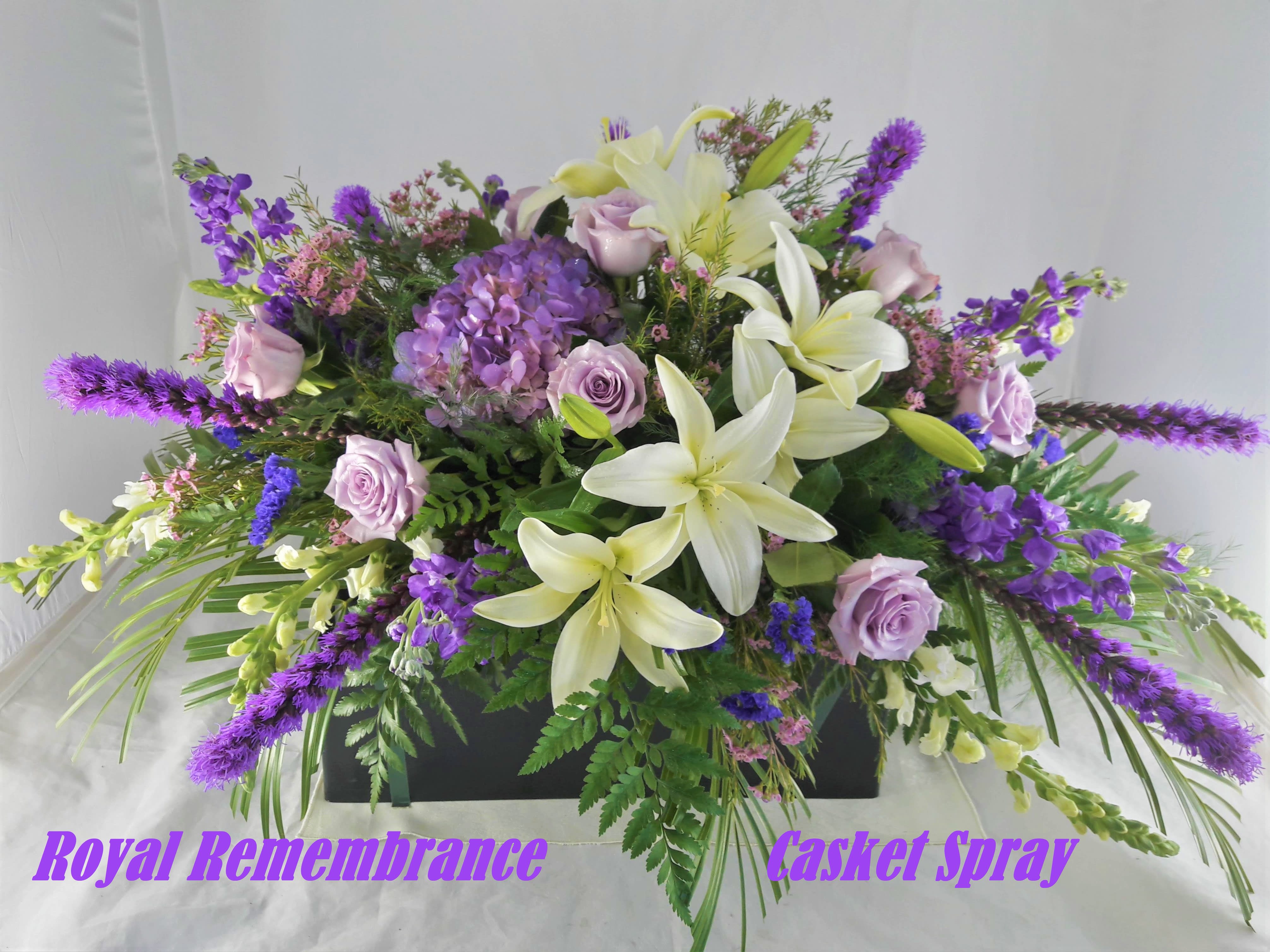Purple and white casket spray with lilies, roses, and hydrangea