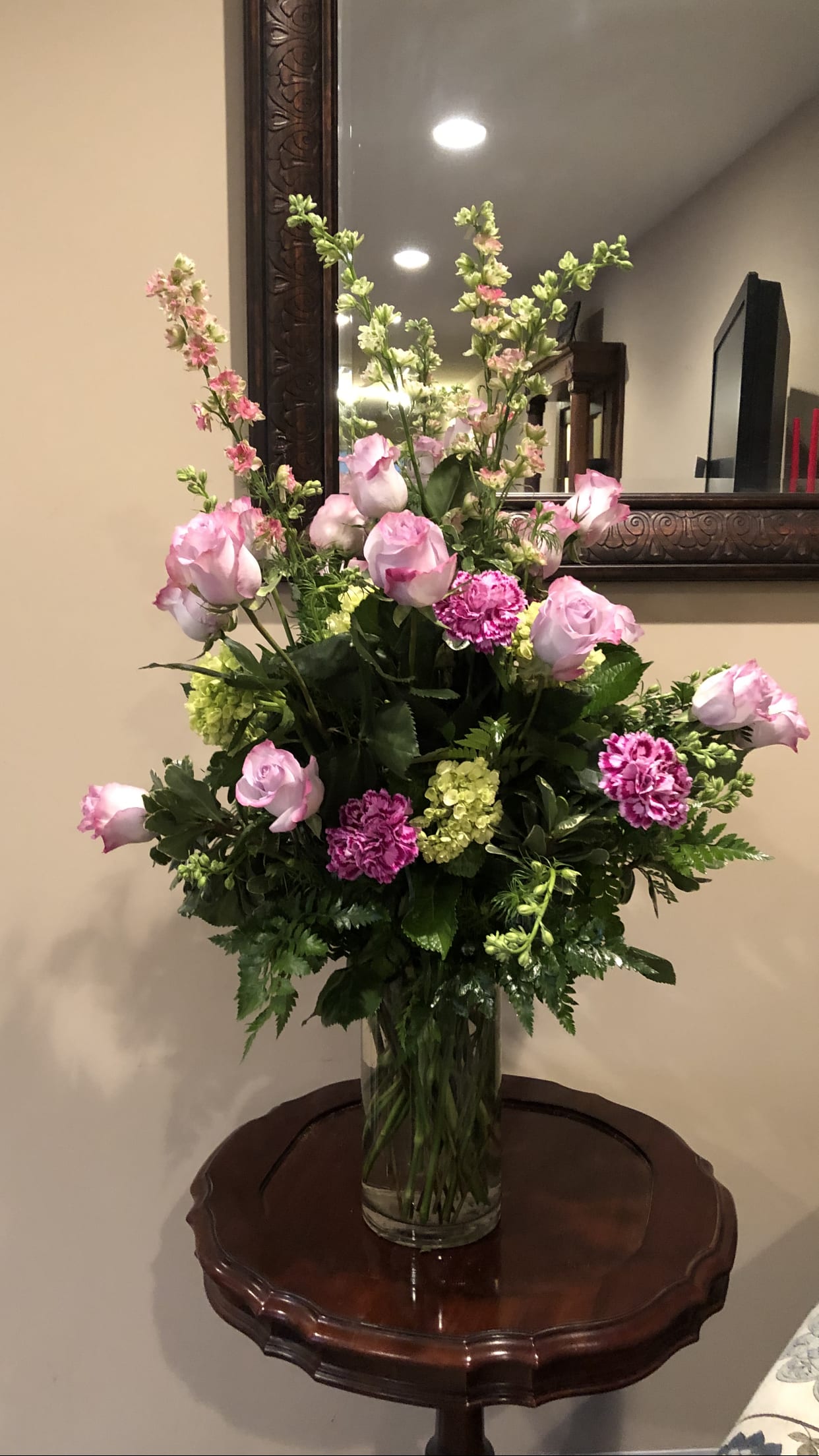 Pink roses and carnations in a clear glass vase