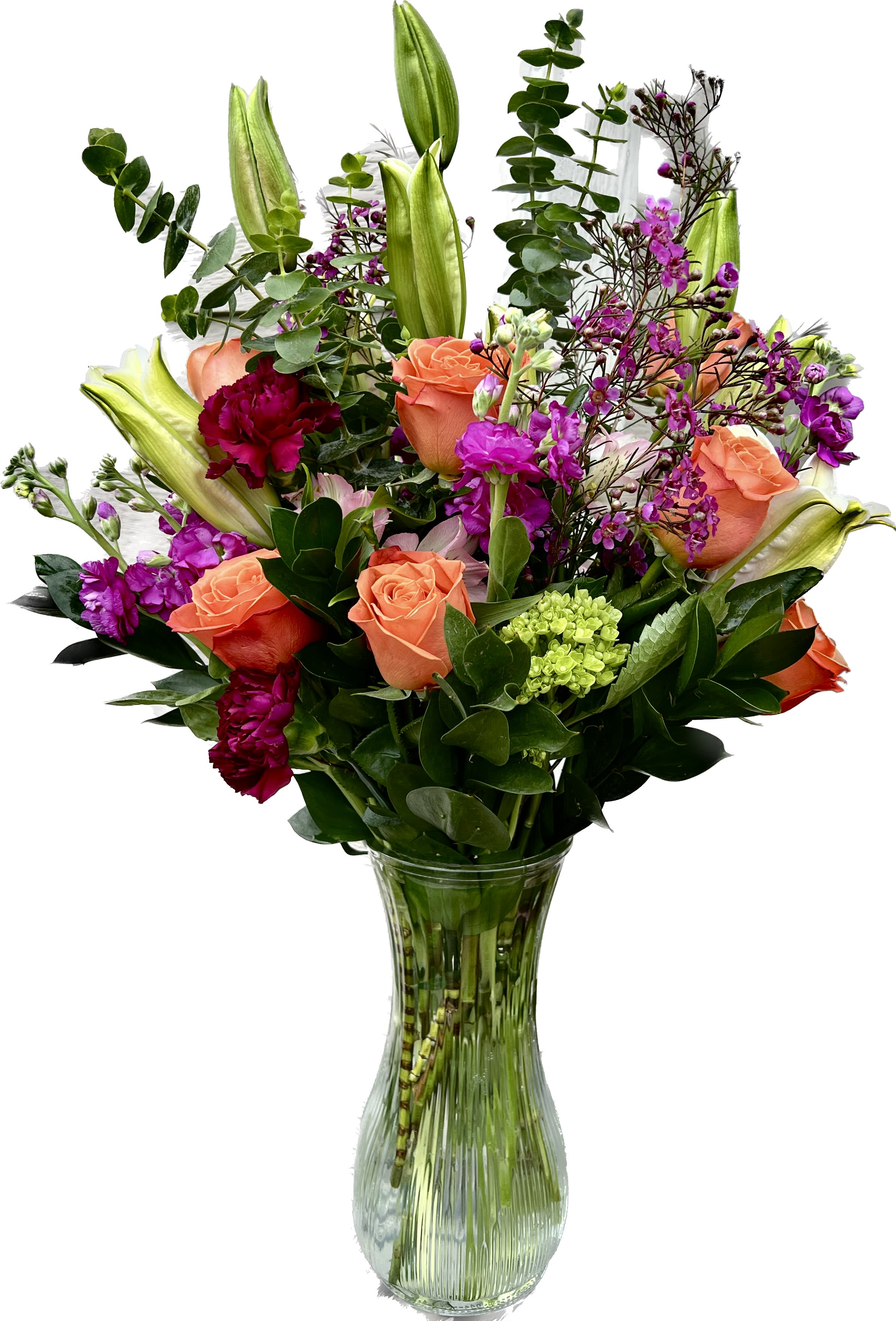 Bouquet of orange roses, purple flowers, and lilies in a glass vase