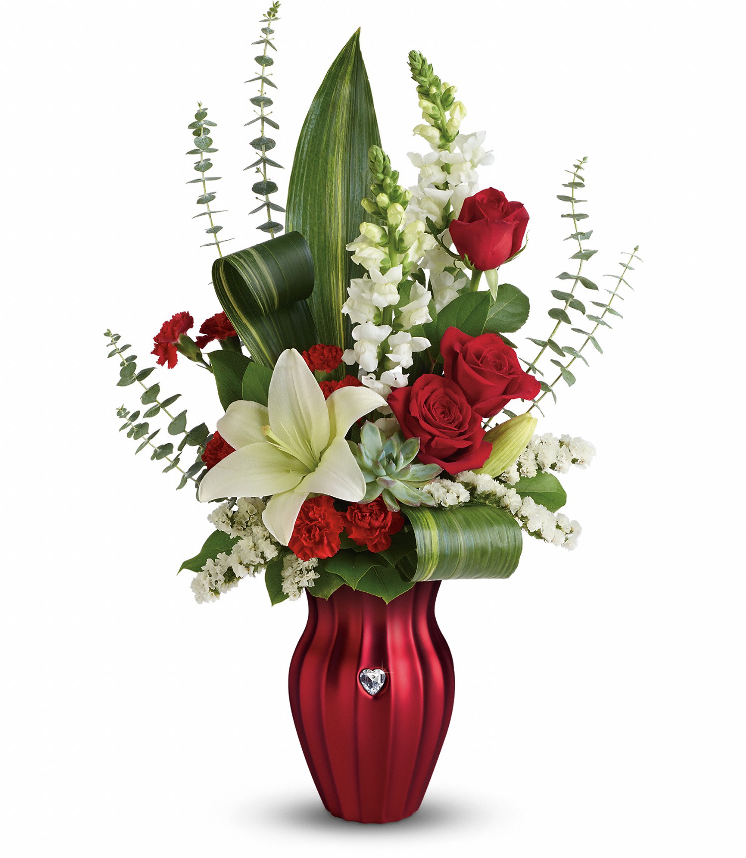 Teleflora's Hearts Aflutter Bouquet - Red roses, white asiatic lilies, red miniature carnations, and white snapdragons are accented with white sinuata statice, variegated aspidistra leaves, spiral eucalyptus and a large green echeveria succulent. Delivered in a Shining Heart vase. Approximately 17" W x 24 1/2" H