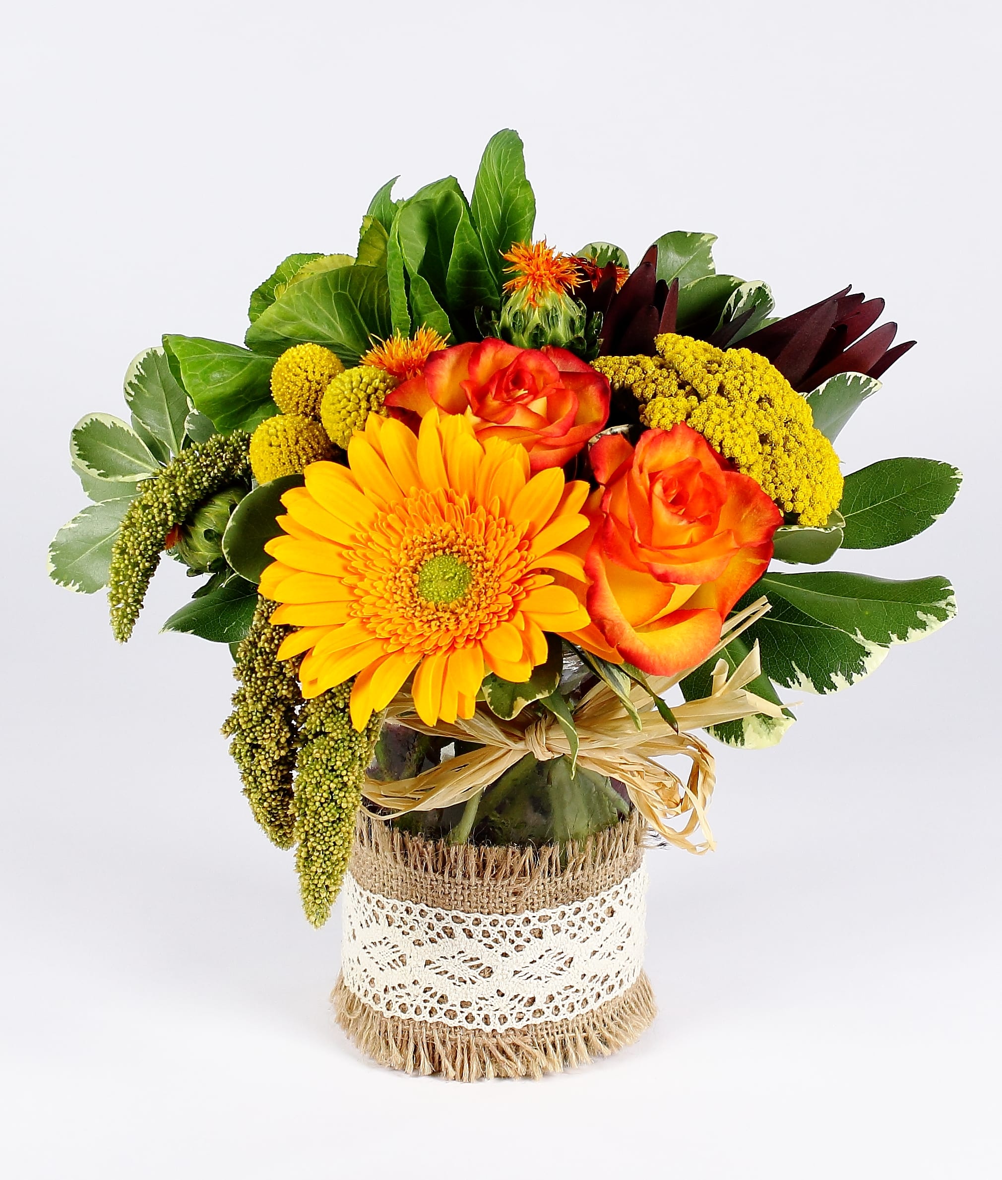 Bouquet of orange roses and a yellow gerbera daisy in a wrapped vase