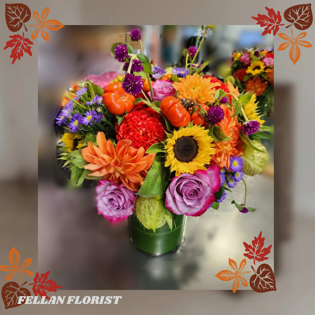 Greta - Beautiful fall arrangement with a mix of seasonal colors and flowers like sunflowers, dahlias, small pumpkins