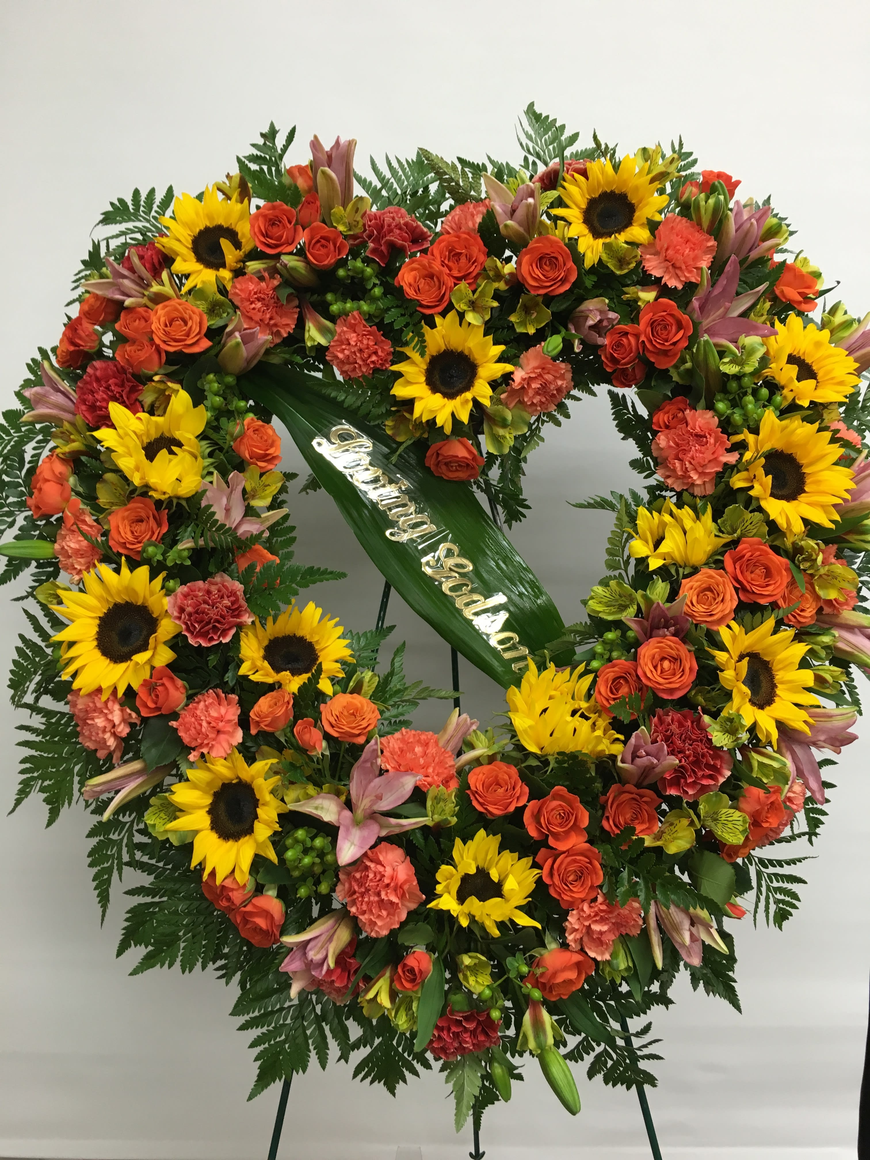 Heart-shaped floral wreath with sunflowers and orange roses