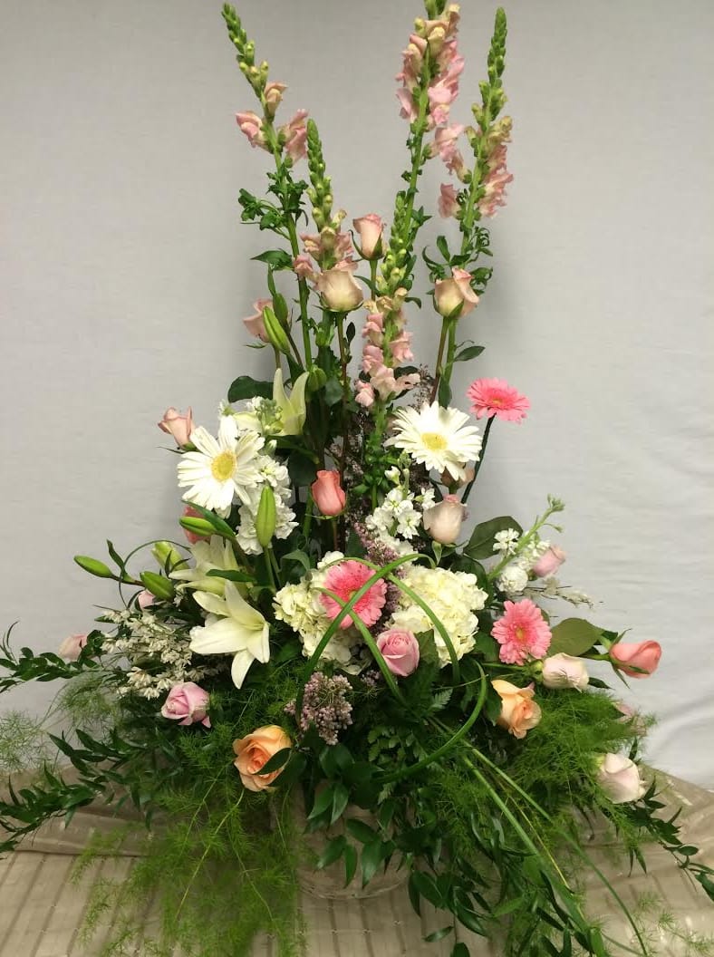 Tall mixed flower arrangement with pink roses, white lilies, and daisies