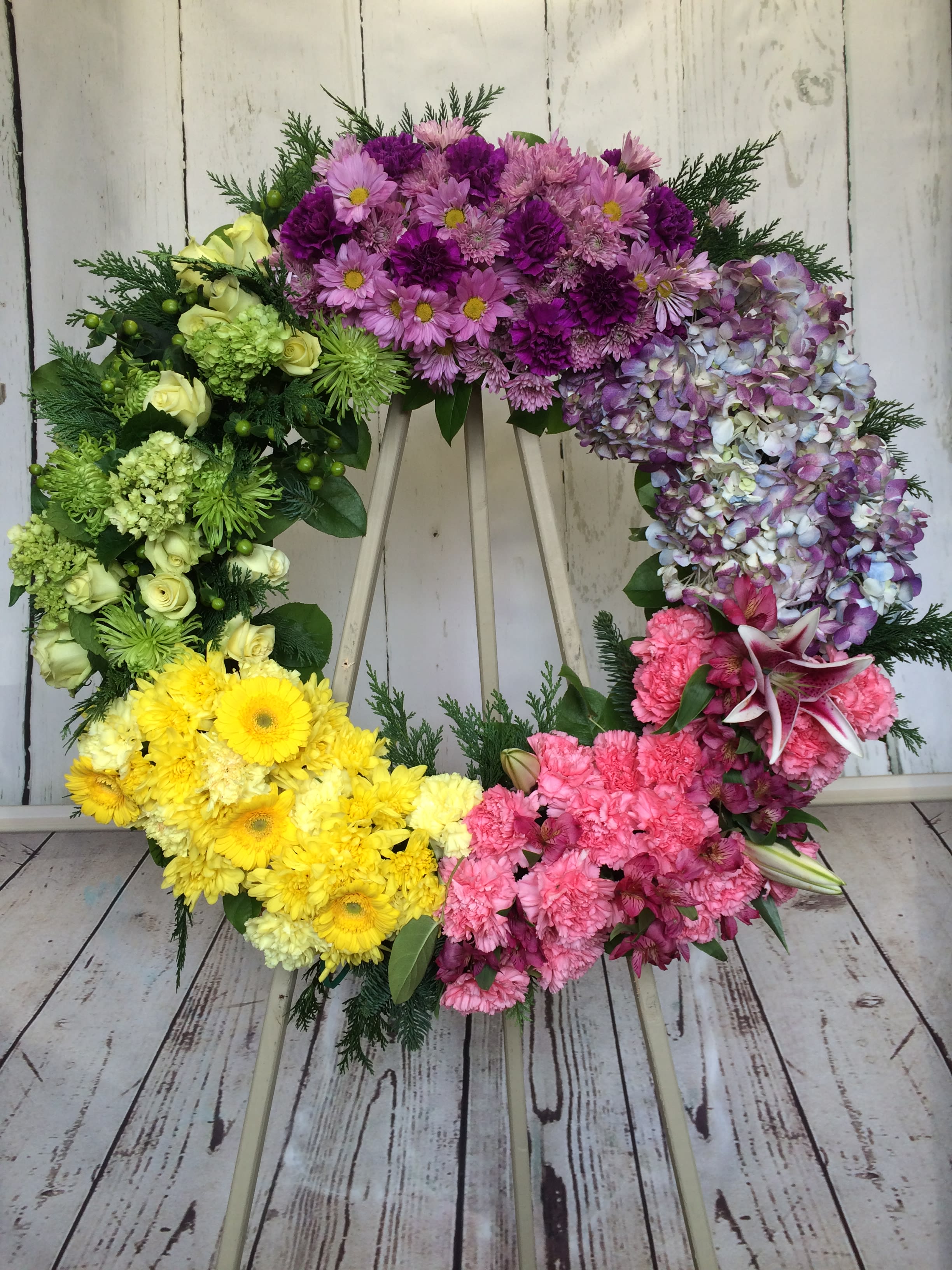 Colorful floral wreath with pink, purple, yellow, and green blooms