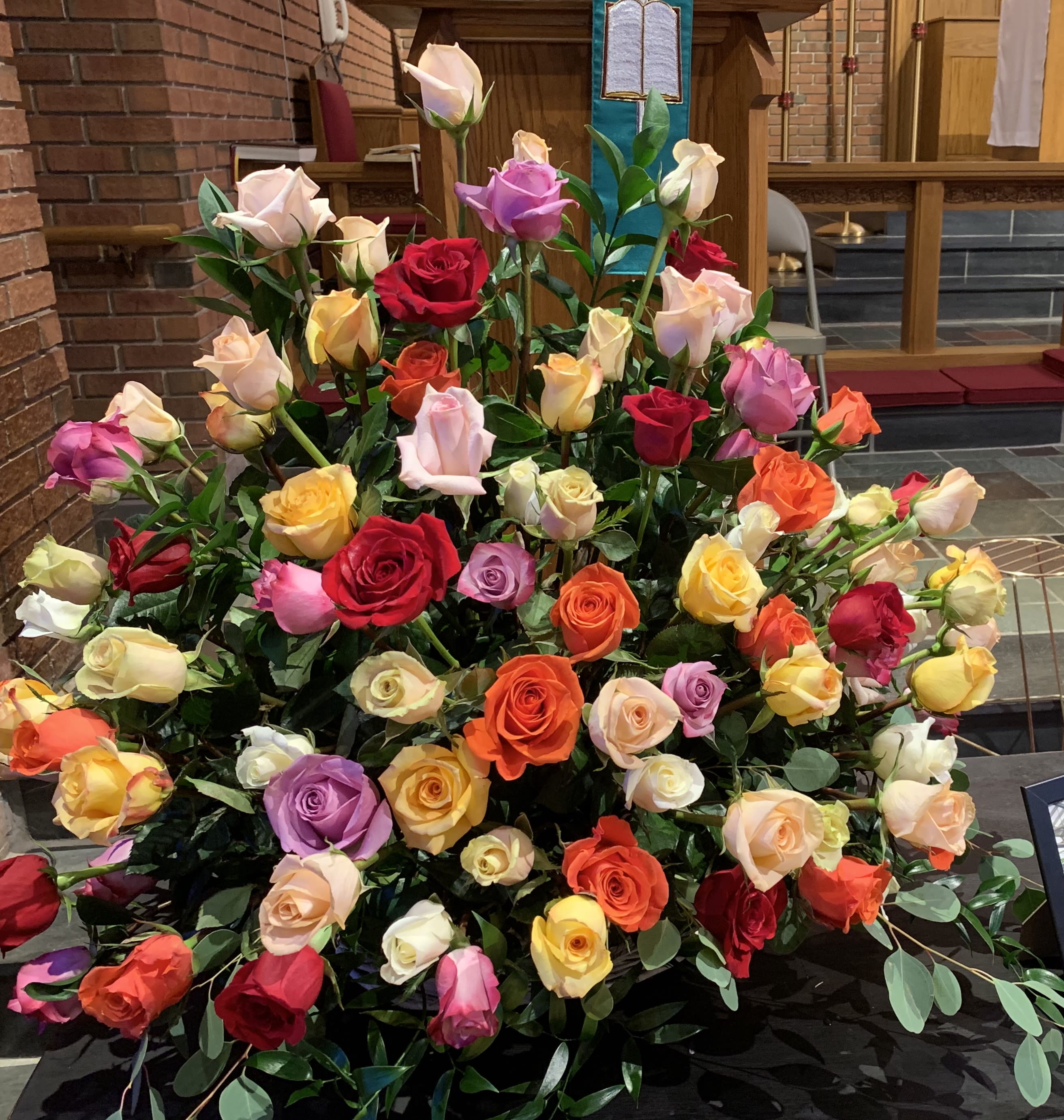 Large arrangement of multicolored roses in a church setting