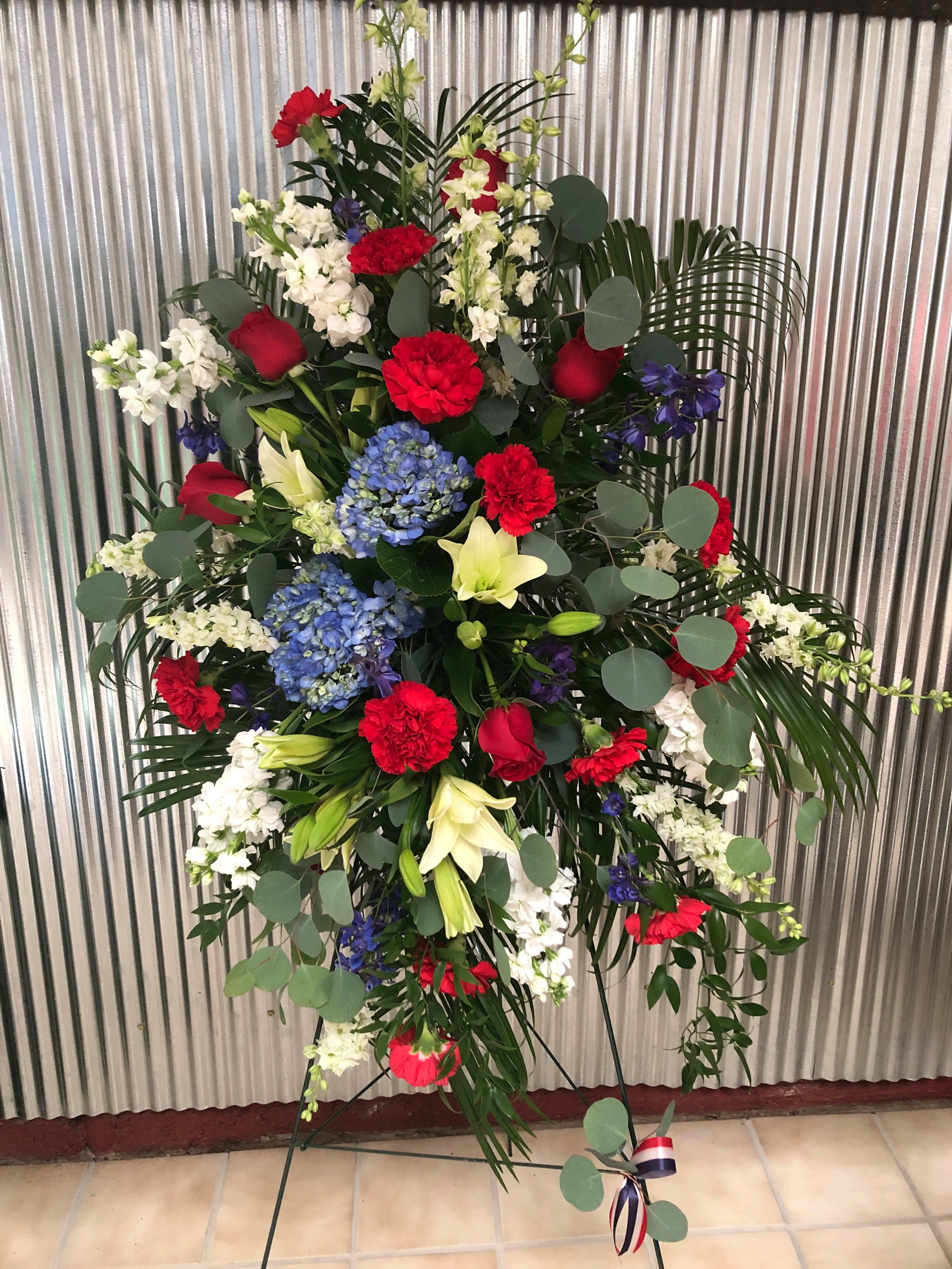 Standing floral spray with red, white, blue, and yellow flowers