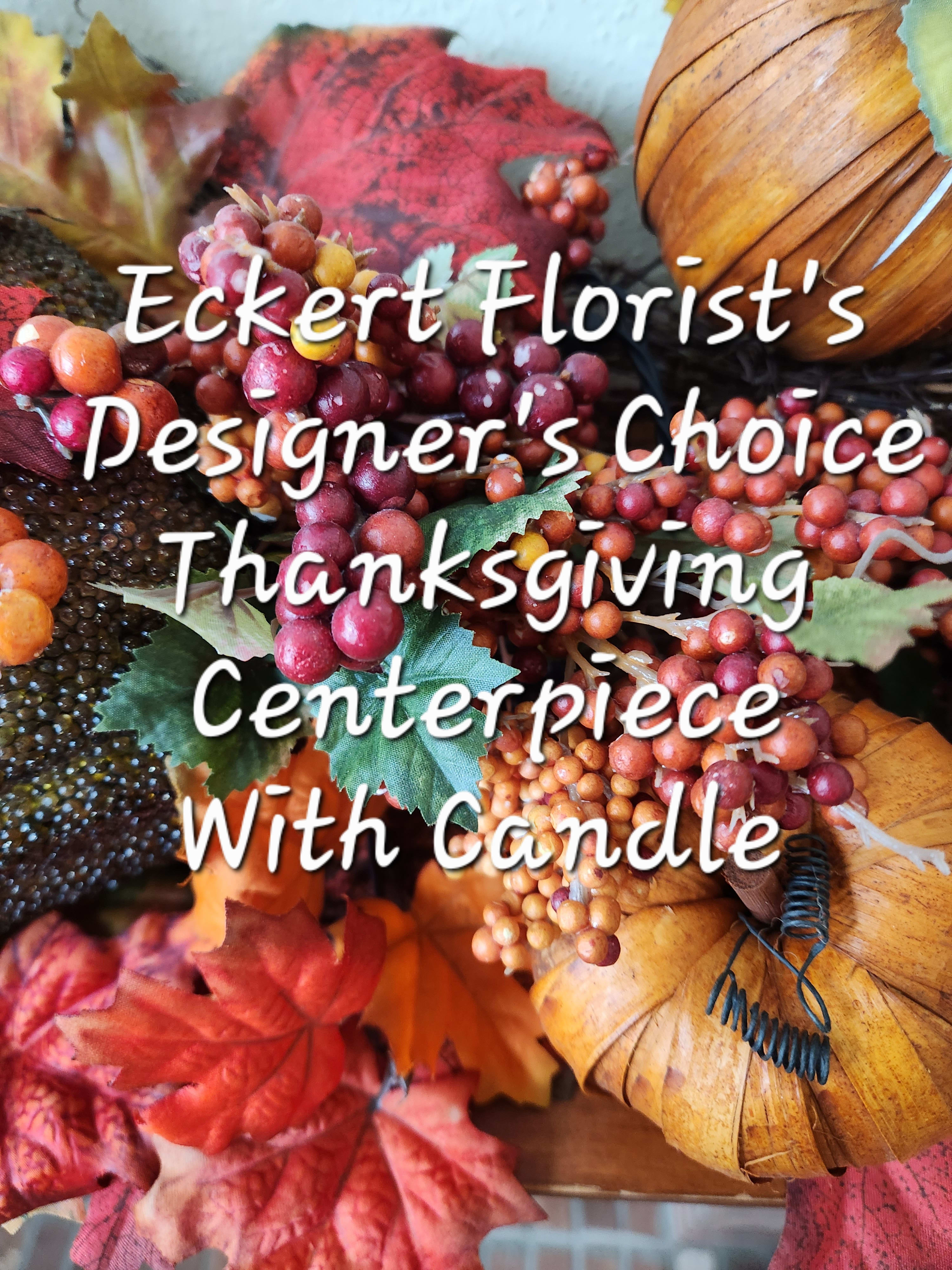 Eckert Florist's Designer's Choice Thanksgiving Centerpiece With Candle - This centerpiece would be a perfect hostess gift or the finishing touch to your thanksgiving table. Arranged in a low container, our designer will pick the finest variety of fresh cut seasonal blooms available adding a coordinating wax taper candle(s). *Please specify in special instructions if No candle(s) is/are desired.  *Please specify in special instructions if you want oblong or round centerpiece. *If No special instructions are mentioned, centerpiece will be oblong with candle(s). 