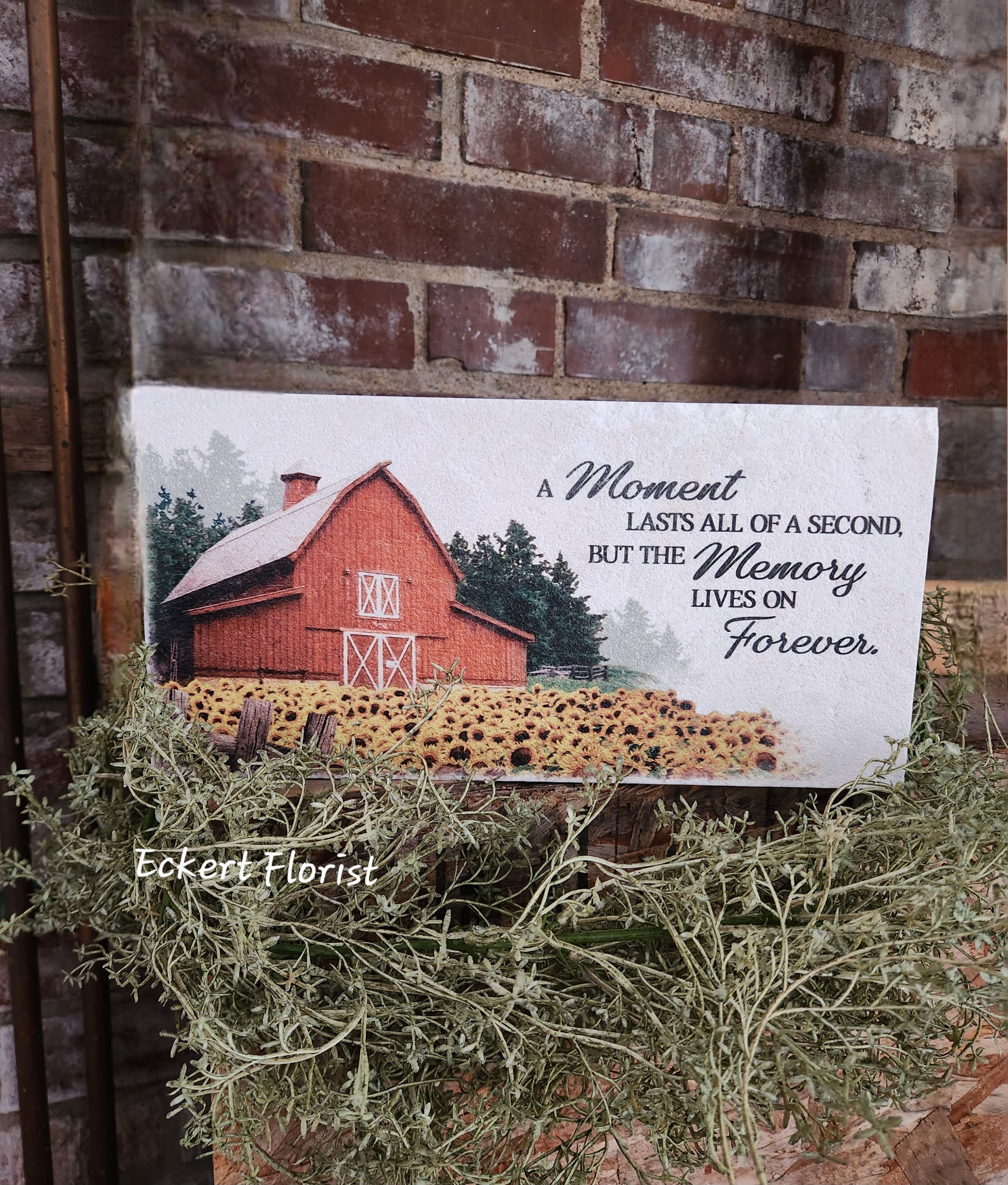 Sympathy card with a barn and sunflower field on a brick wall