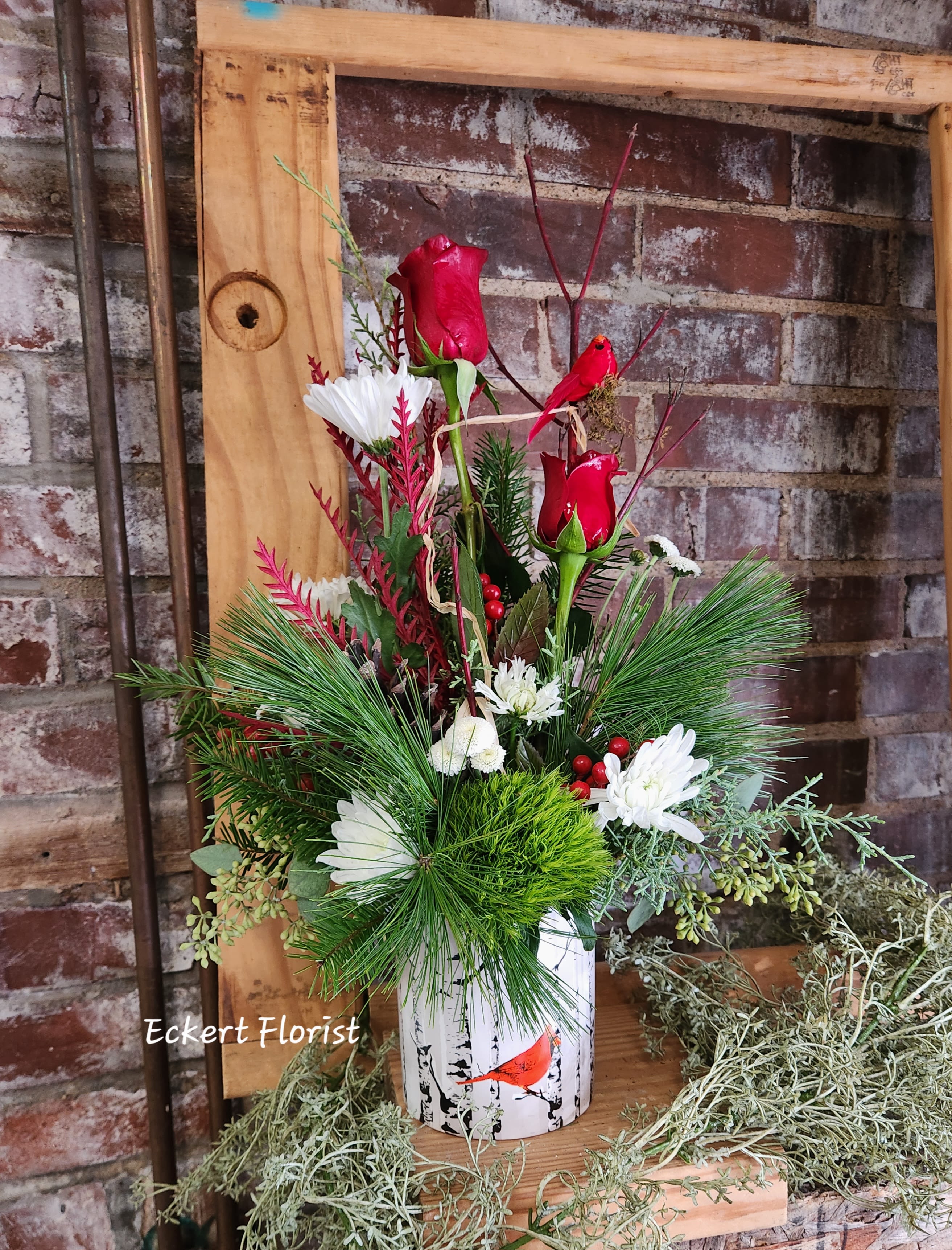 Red roses and white daisies in a birch-print container