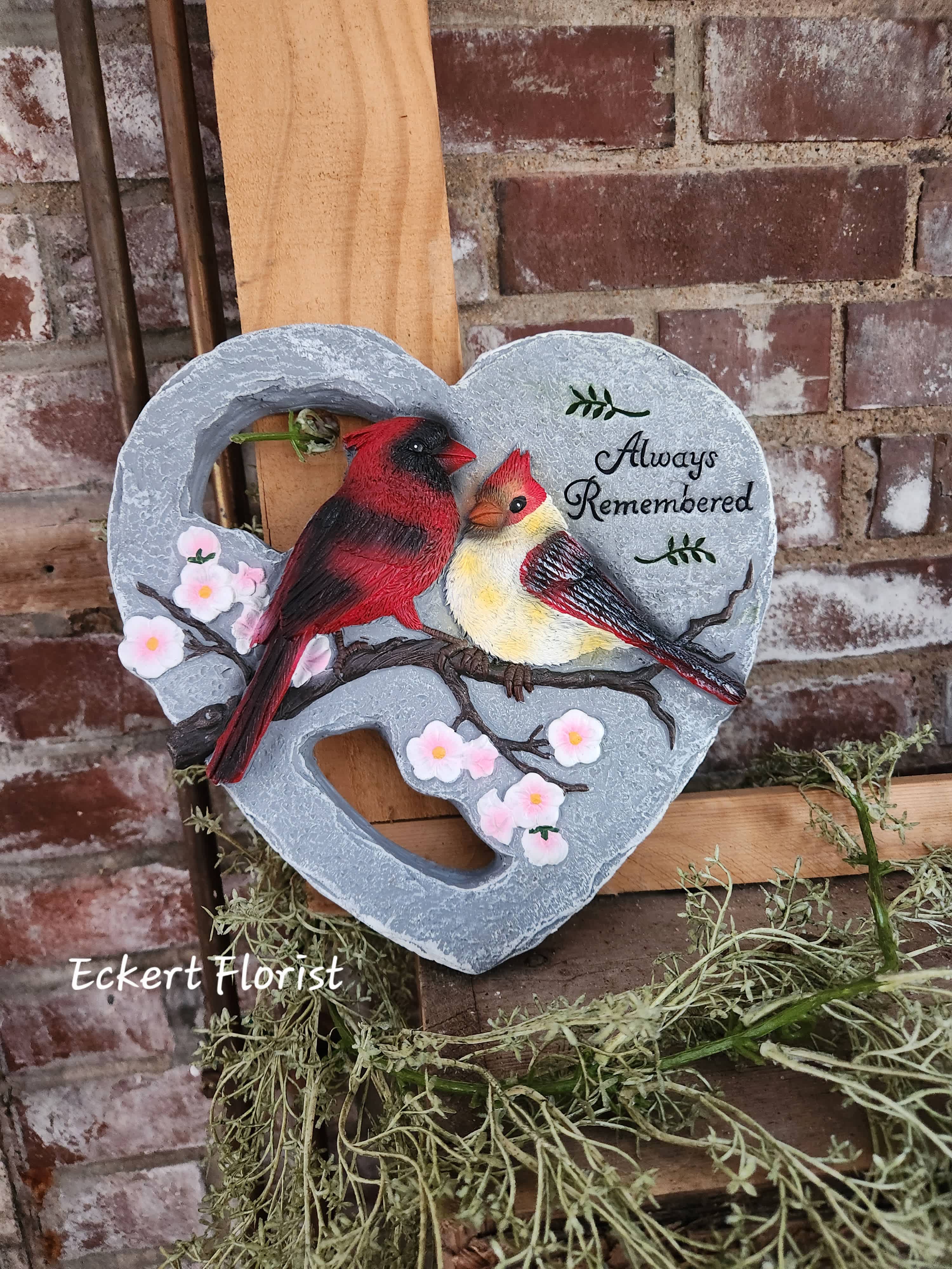 Heart-shaped memorial plaque with two birds and small pink blossoms